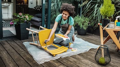  woman on the patio painting a wood chair